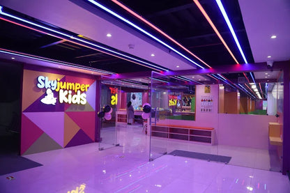 Entrance area of SkyJumper Kids trampoline park with colorful geometric walls and neon ceiling lights at Metro World Mall Gurgaon