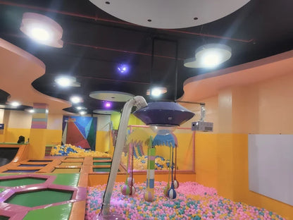 Indoor kids trampoline park area with pink and yellow ball pit and vibrant multicolor wall murals in Gurgaon location