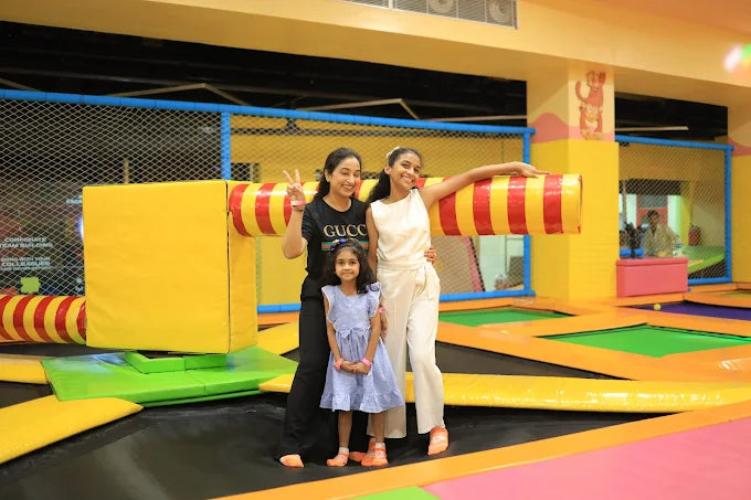 Two women posing with a young girl inside a colorful trampoline park play area at Metro World Mall Gurgaon
