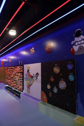 Indoor kids play area with space-themed wall art featuring planets and an astronaut at a trampoline park in Gurgaon