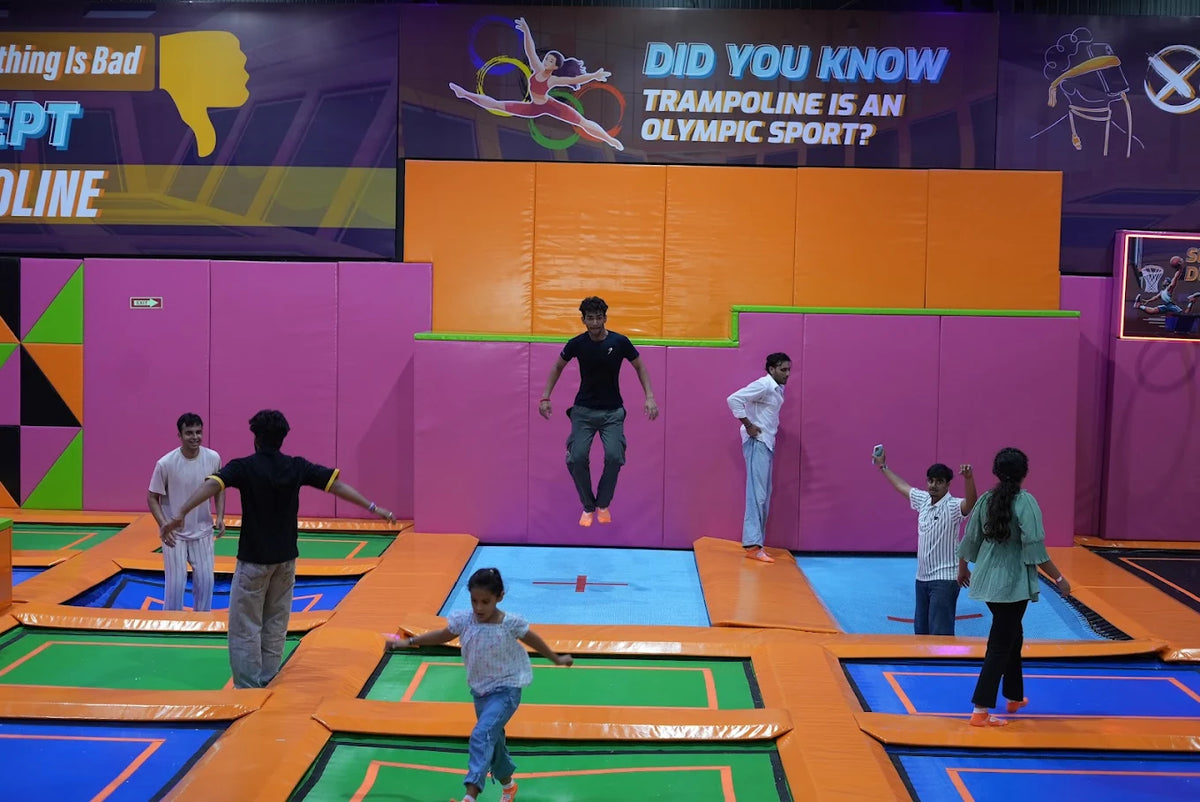 Young people enjoy jumping on trampolines in an indoor park.