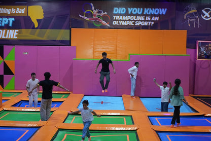 Young people enjoy jumping on trampolines in an indoor park.