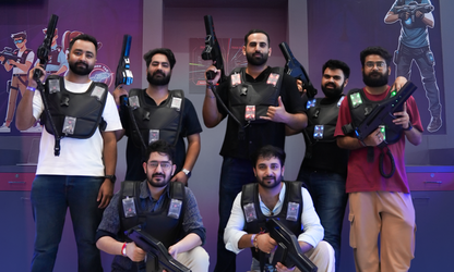 A group of young men in laser tag vests and gear pose with their weapons.