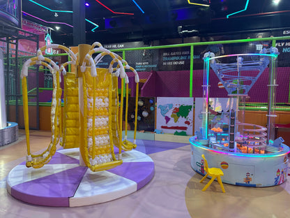 A colorful indoor playground with a spinning ride and a ball pit game.