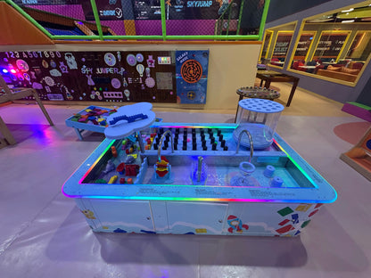 Toy water table with colorful lights and building blocks in a playroom setting.