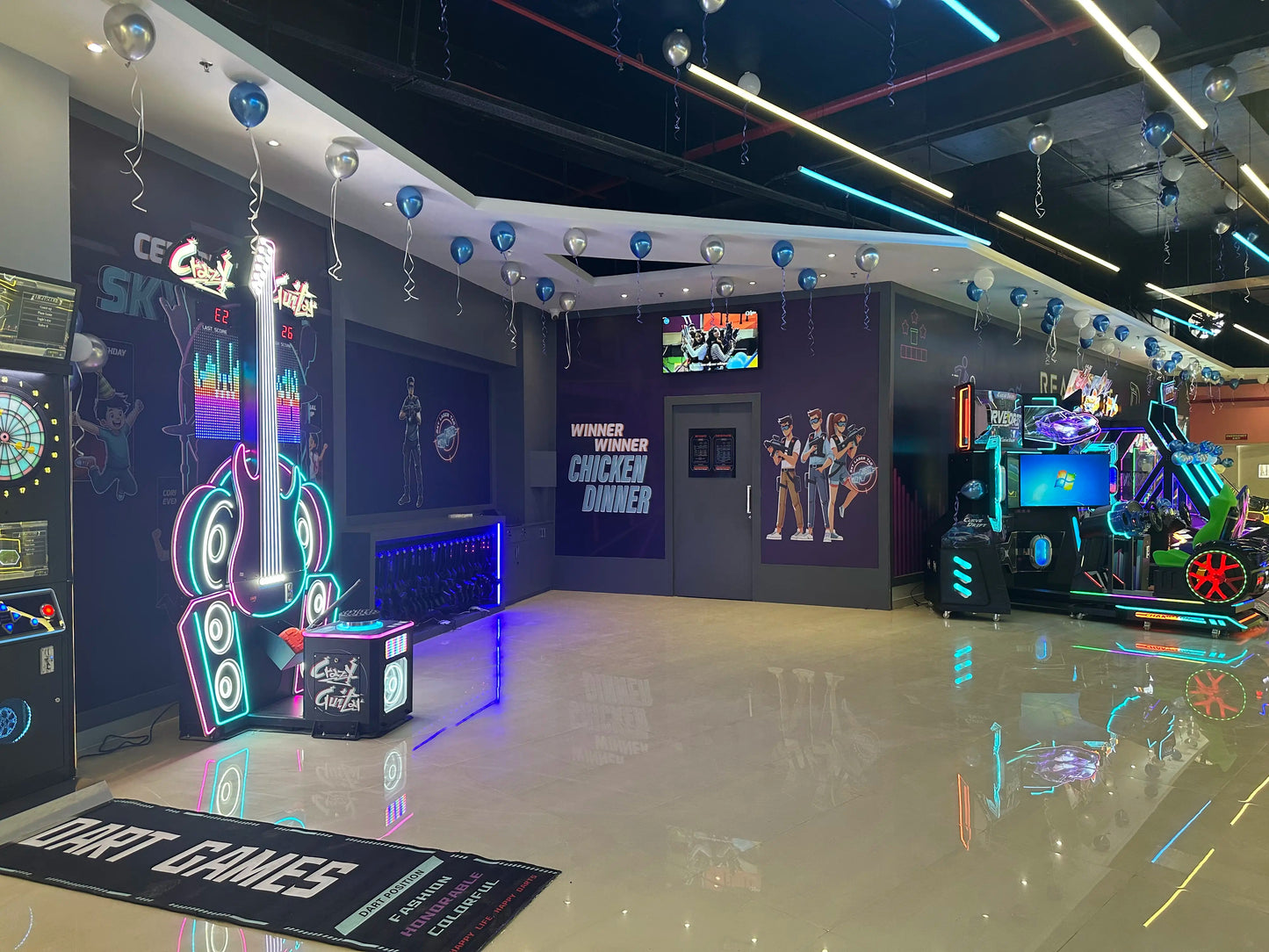 An arcade with neon lights, game machines, and balloons.