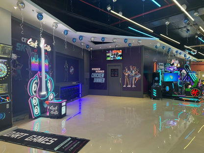 An arcade with neon lights, game machines, and balloons.