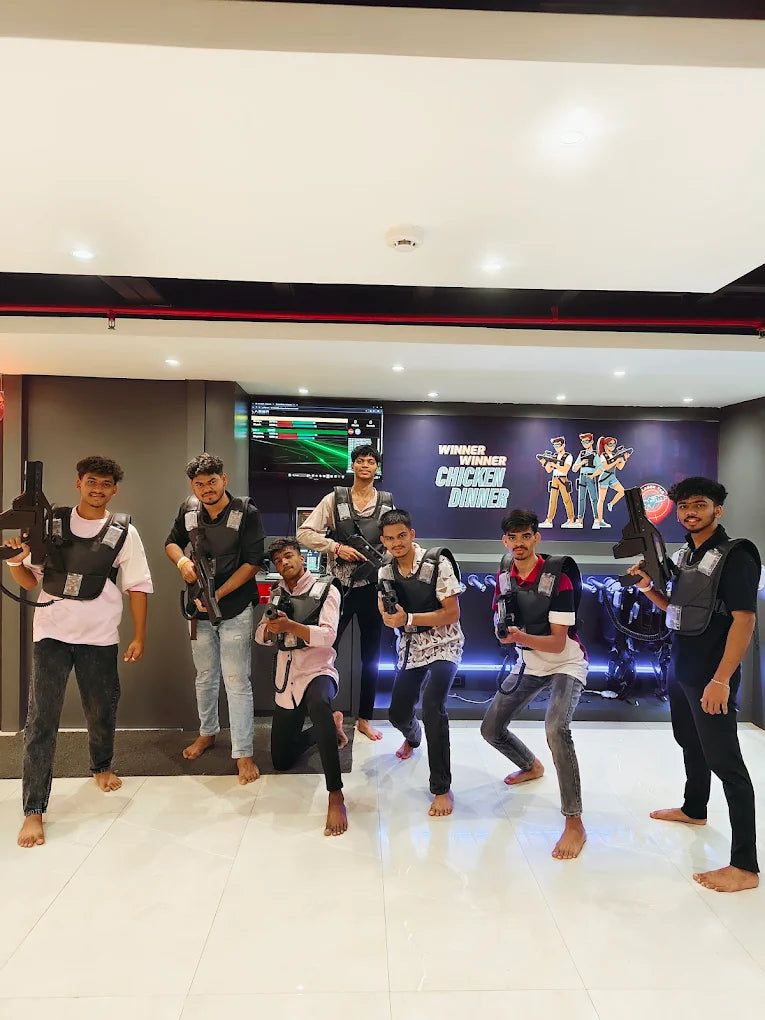 Young people in laser tag vests and holding guns pose for a photo in an indoor arena.