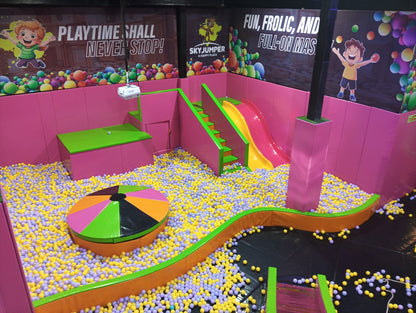 A vibrant indoor playground with a ball pit, slides, and colorful decorations, filled with young children.