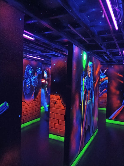 A dimly lit laser tag arena with neon lights and murals of characters.