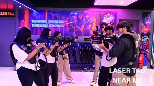 Young adults play laser tag in a dimly lit arena, holding futuristic phasers and wearing vests.