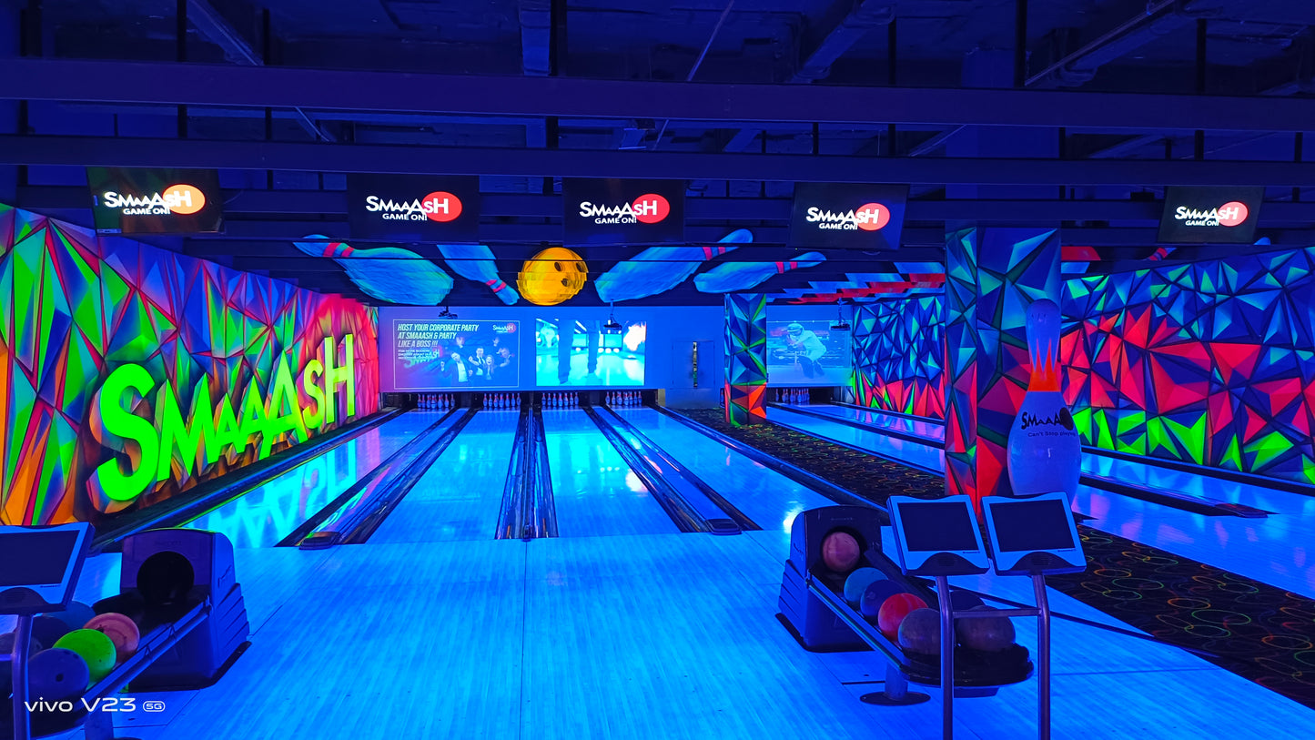 A brightly lit bowling alley with neon colors and a "Smash" logo.