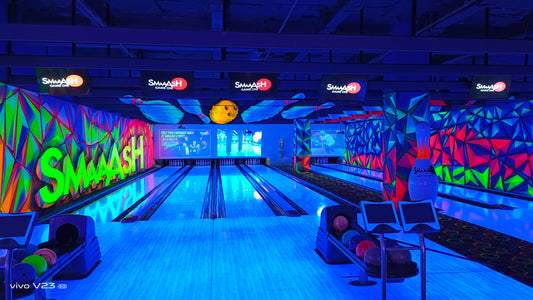 A brightly lit bowling alley with neon colors and a "Smash" logo.