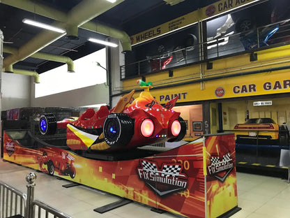 A red race car simulator ride in an arcade, with a yellow and red checkered flag design.