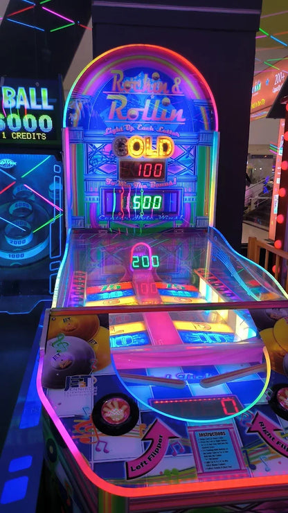 A brightly lit arcade game with neon lights and a "Rockin & Rollin" theme. The game displays scores of 100, 500, and 200.
