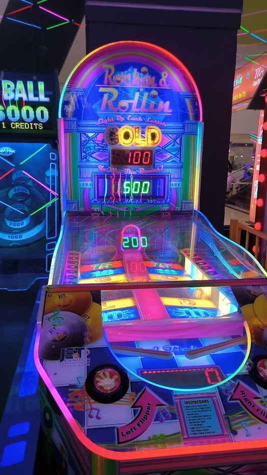 A brightly lit arcade game with neon lights and a "Rockin & Rollin" theme. The game displays scores of 100, 500, and 200.