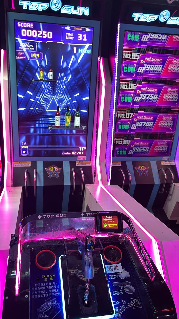 Two Top Gun arcade games with guns and neon lights.