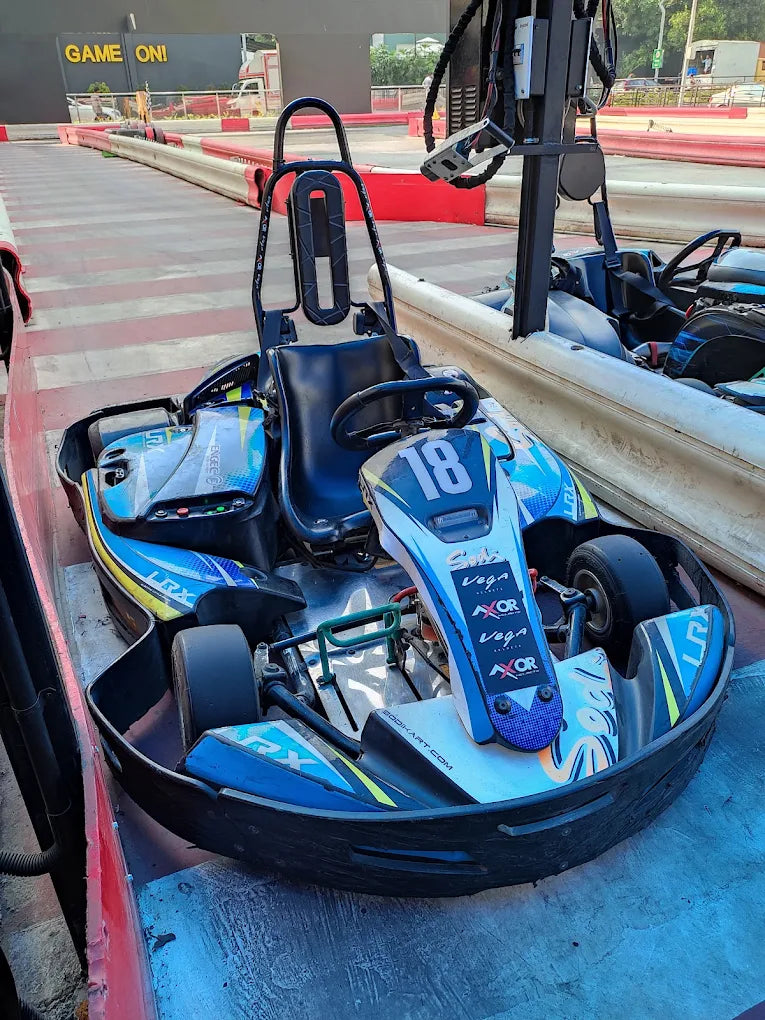 A go-kart with the number 18 on it sits on a track, ready for racing.