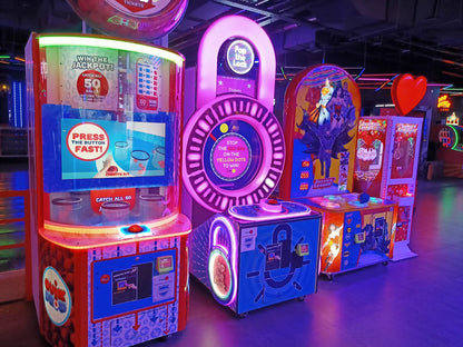 Arcade game machines with bright lights and colorful displays, likely in an entertainment venue.