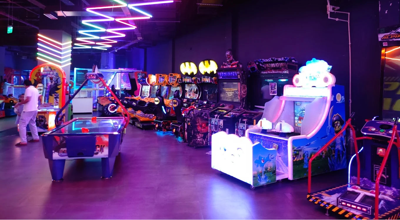 An arcade with neon lights, game machines, and people playing.