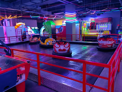 Bumper cars in an arcade, with colorful lights and game machines in the background.