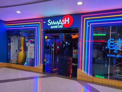 A brightly lit bowling alley entrance with neon lights and a large bowling pin statue.