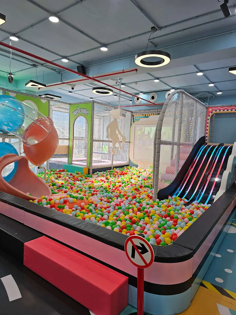 A colorful ball pit with slides and play structures for children.