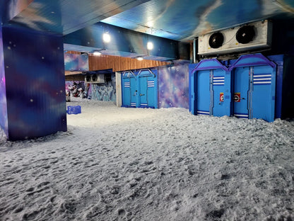 A snowy indoor amusement area with blue doors and playful decorations.