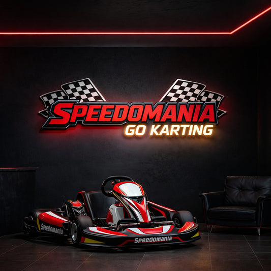 A go-kart with the "Speedomania Go Karting" logo is displayed in a dark room with neon lights and a black armchair.