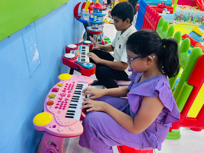 Two children play toy keyboards in a colorful playroom.