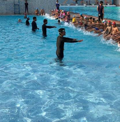 Swim instructor teaching a group of swimmers in a pool