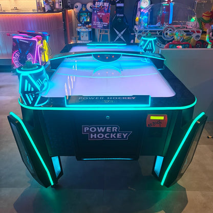 An illuminated air hockey table in an arcade, with neon lights and game machines in the background.