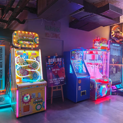 Arcade with colorful, glowing games and a bowling advertisement.
