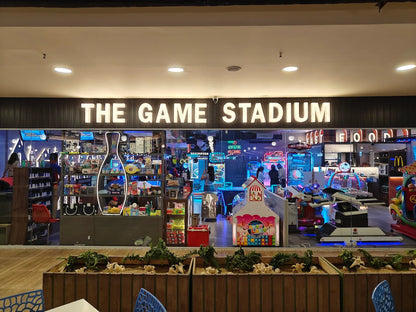 An arcade and game store called "The Game Stadium" with various arcade games and a bowling pin display.