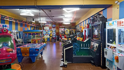 An arcade filled with colorful game machines and an air hockey table.