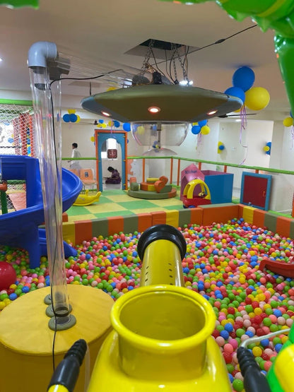 A colorful indoor playground with a ball pit and children playing.