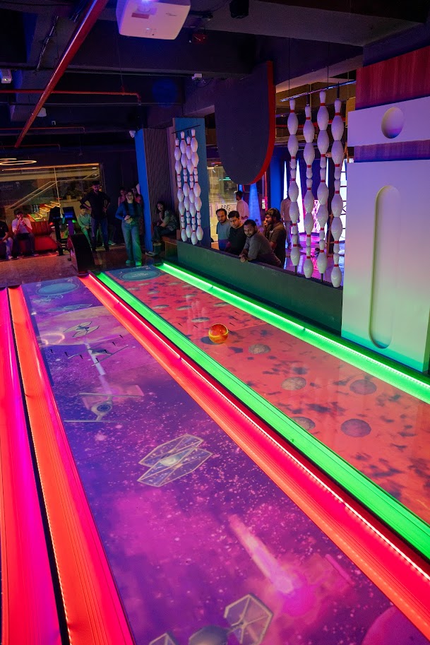 Indoor bowling alley with colorful lanes and people in the background