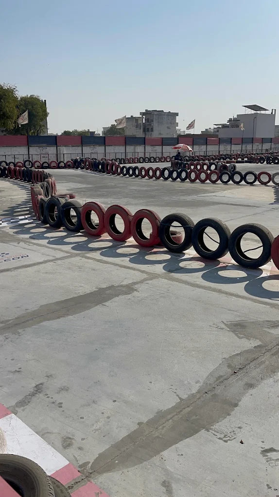A go-kart track with tire barriers and a clear blue sky.