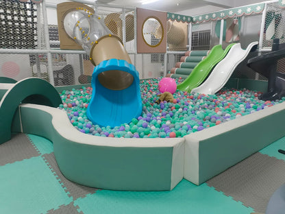 A colorful ball pit with slides and a tube slide in a children's indoor play area.