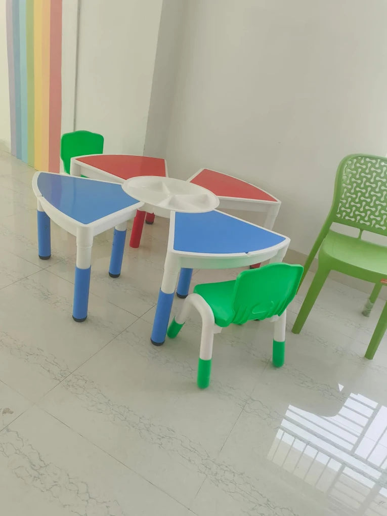 Colorful children's tables and chairs are set up in a bright room.