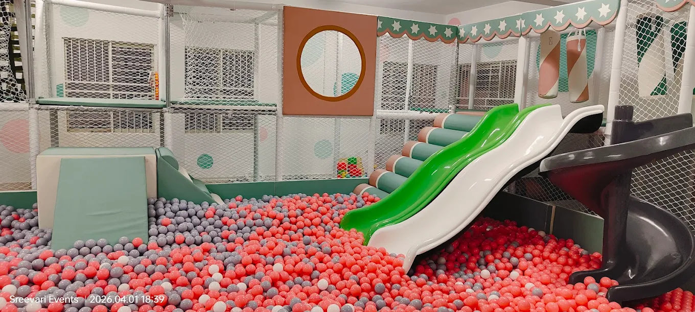A colorful indoor playground with slides and a ball pit for young children.
