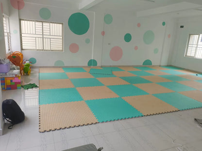 A brightly colored playroom with foam floor mats and wall decorations for young children.