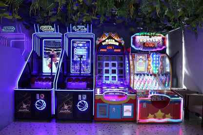 Row of illuminated arcade machines including shooting and bottle toss games in a vibrantly lit indoor play zone