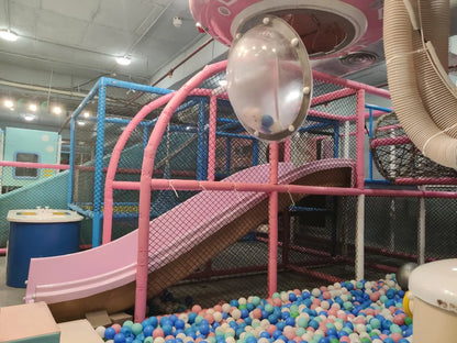 Children's indoor play area with pink slide and ball pit.