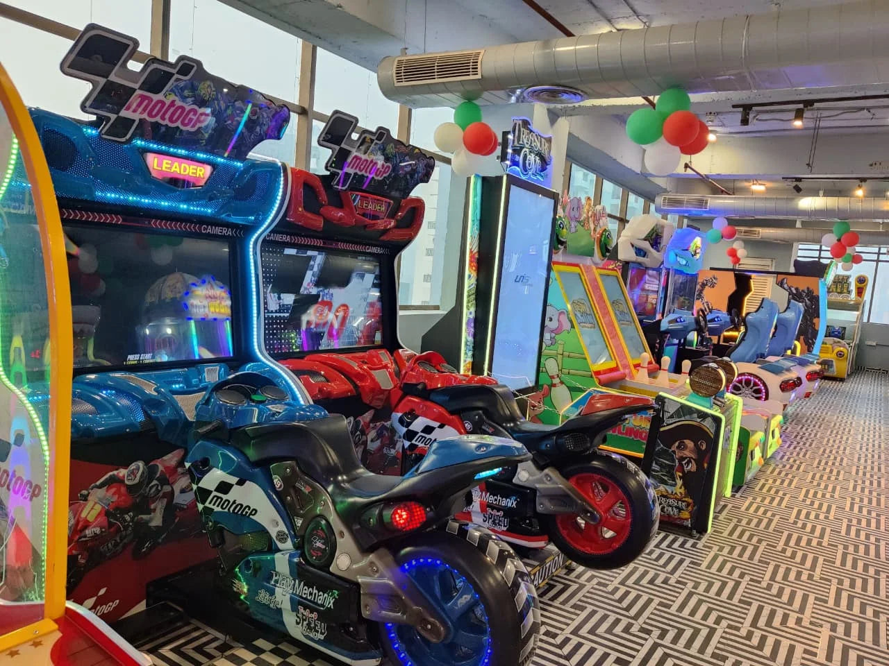 Row of vibrant motorbike racing arcade games with illuminated controls in an energetic indoor entertainment space