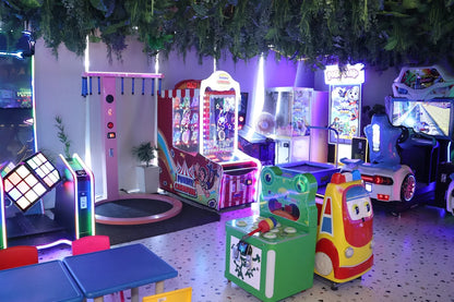 Children's play area with colorful arcade machines and toys.