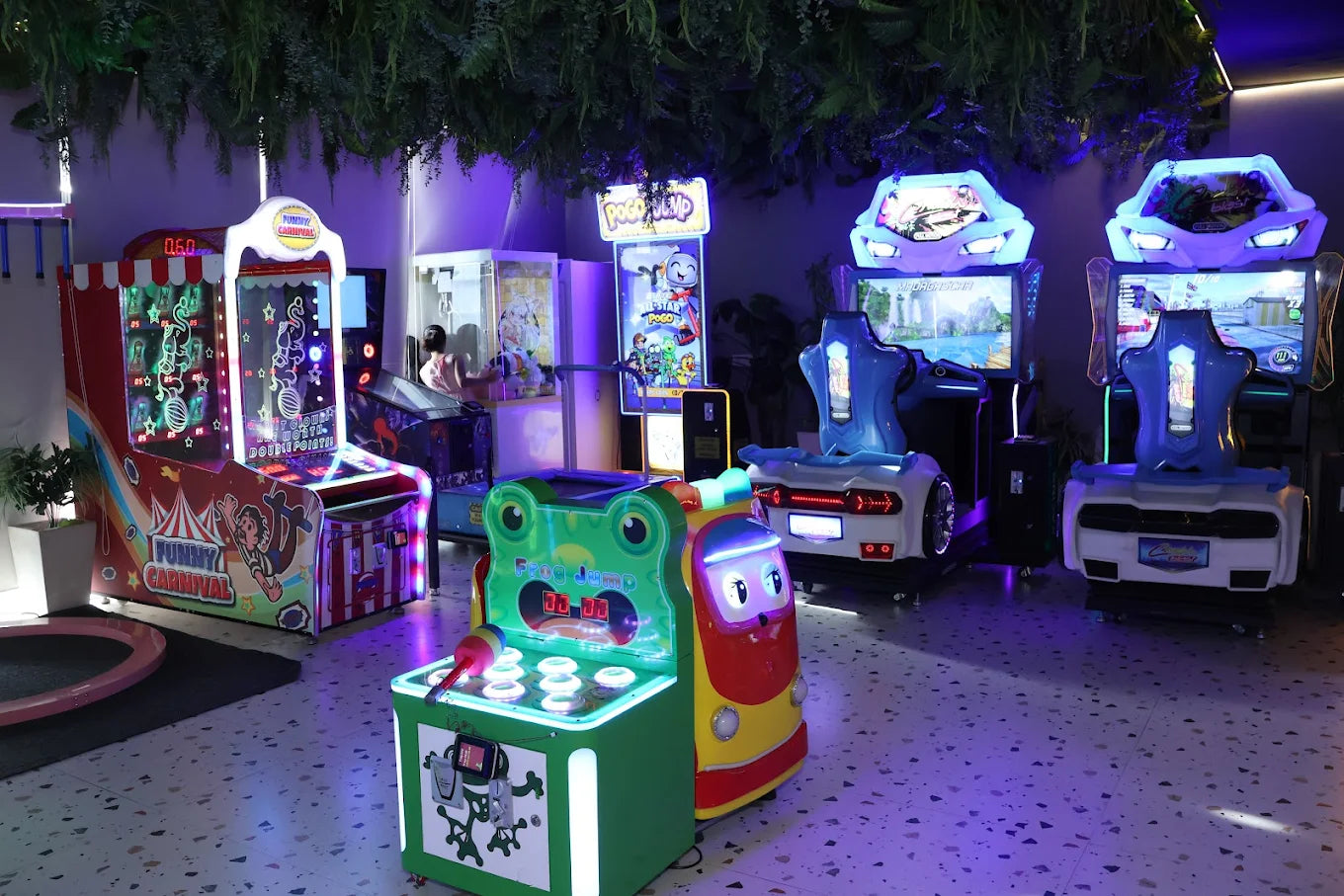 Indoor play area with vibrant arcade machines, interactive racing simulators, and fun colorful gaming units