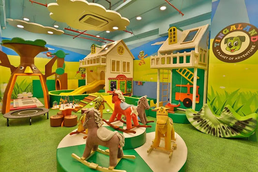 Colorful indoor play area with wooden rocking horses, playground structures, and vibrant wall art at Tingaland Sector 104 Noida