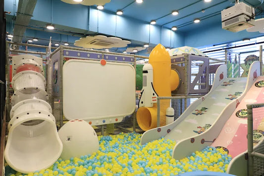 Children's indoor play area with slides and colorful ball pit.