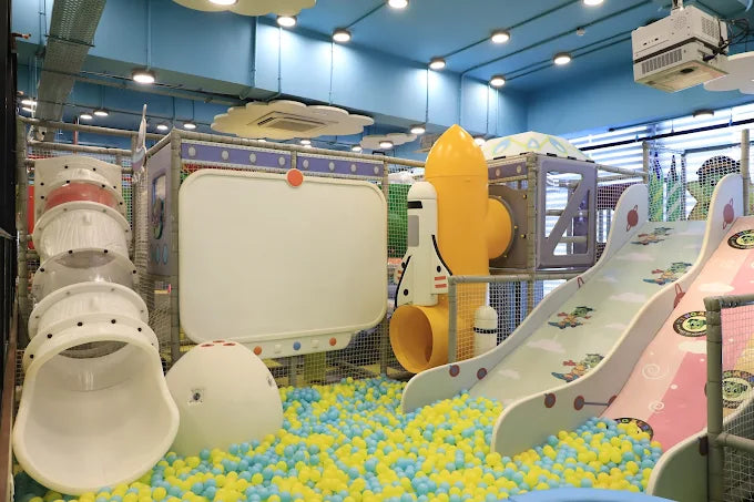 Children's indoor play area with slides and colorful ball pit.